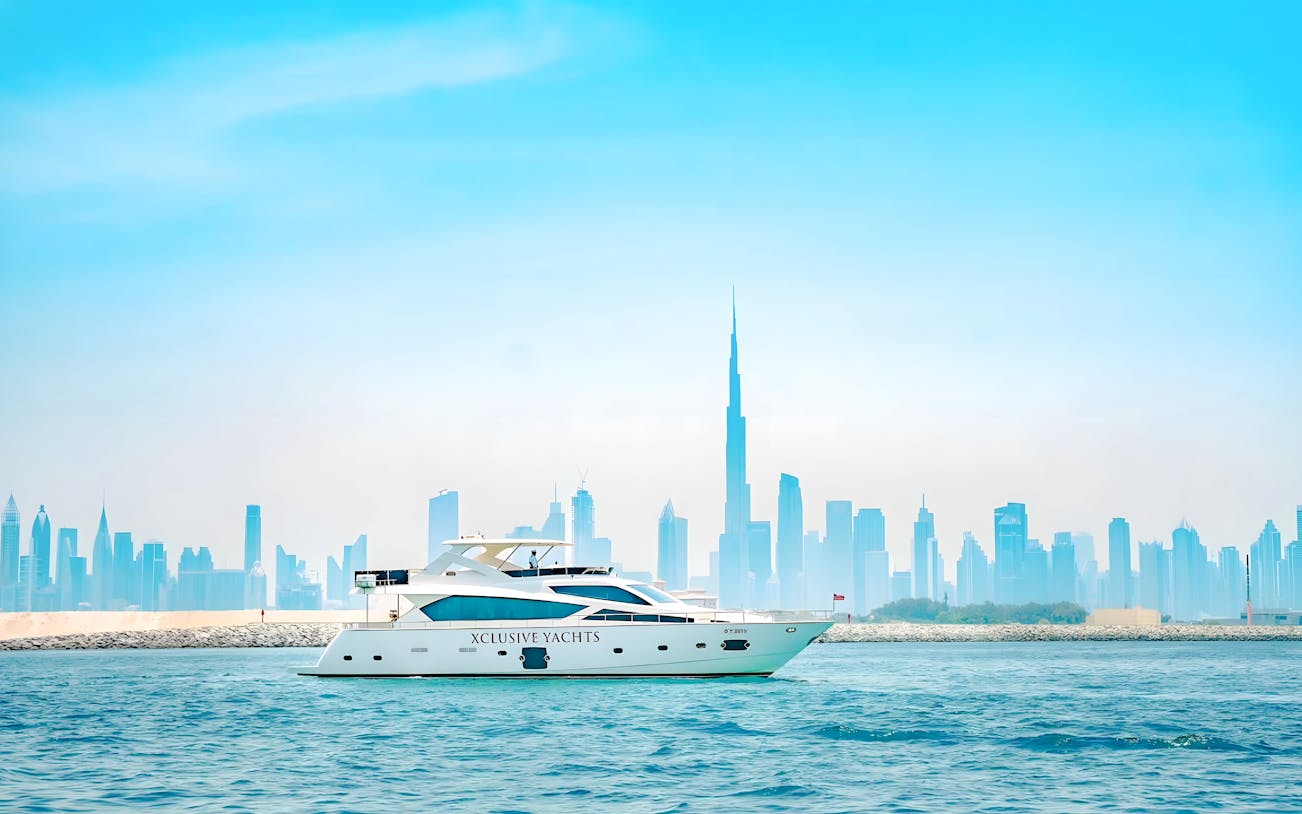 Yacht sailing through canal with Burj Khalifa and Dubai skyline in background.