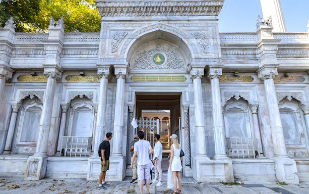 Visitors at the entrance of Topkapi Palace, Istanbul, exploring historic architecture.