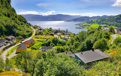 View of Hardangerfjord in Norway with houses and lush greenery.