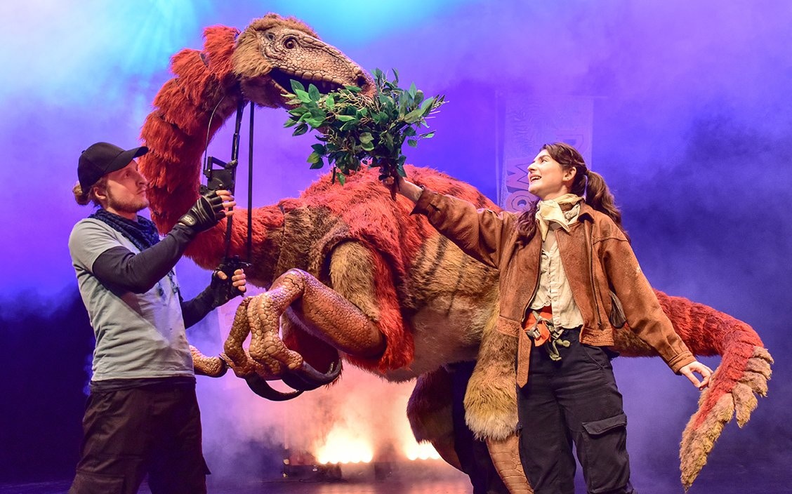 Stage performance of Dinosaur World Live with puppeteers and dinosaur, Westend.