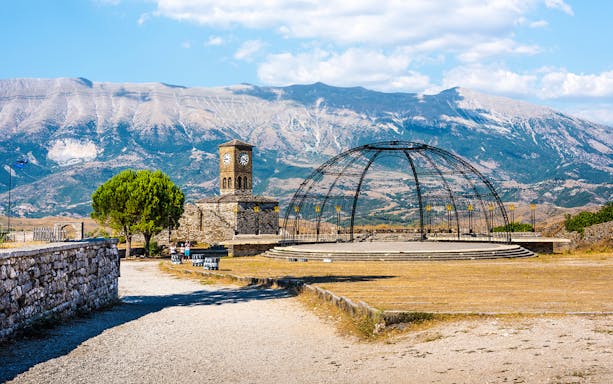 Gjirokaster Castle compound with clock tower and mountain backdrop, Albania.