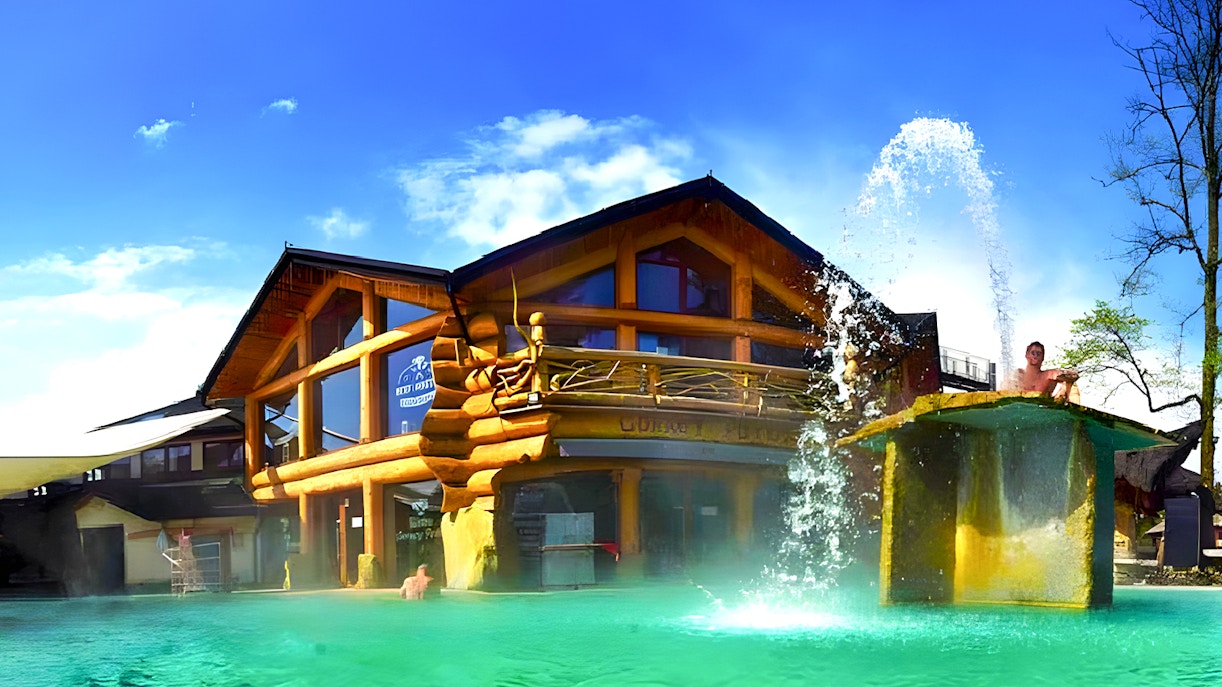 Goracy Potok Thermal Bath with wooden lodge and water fountain in Krakow.