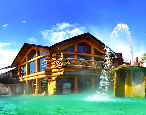 Goracy Potok Thermal Bath with wooden lodge and water fountain in Krakow.