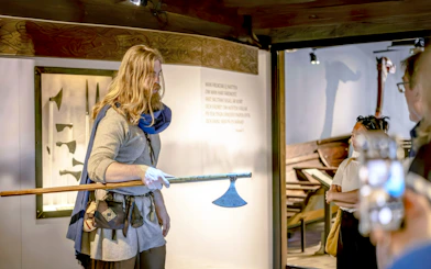 Costumed guide demonstrating Viking axe at The Viking Museum, Stockholm.