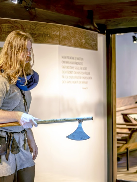 Costumed guide demonstrating Viking axe at The Viking Museum, Stockholm.