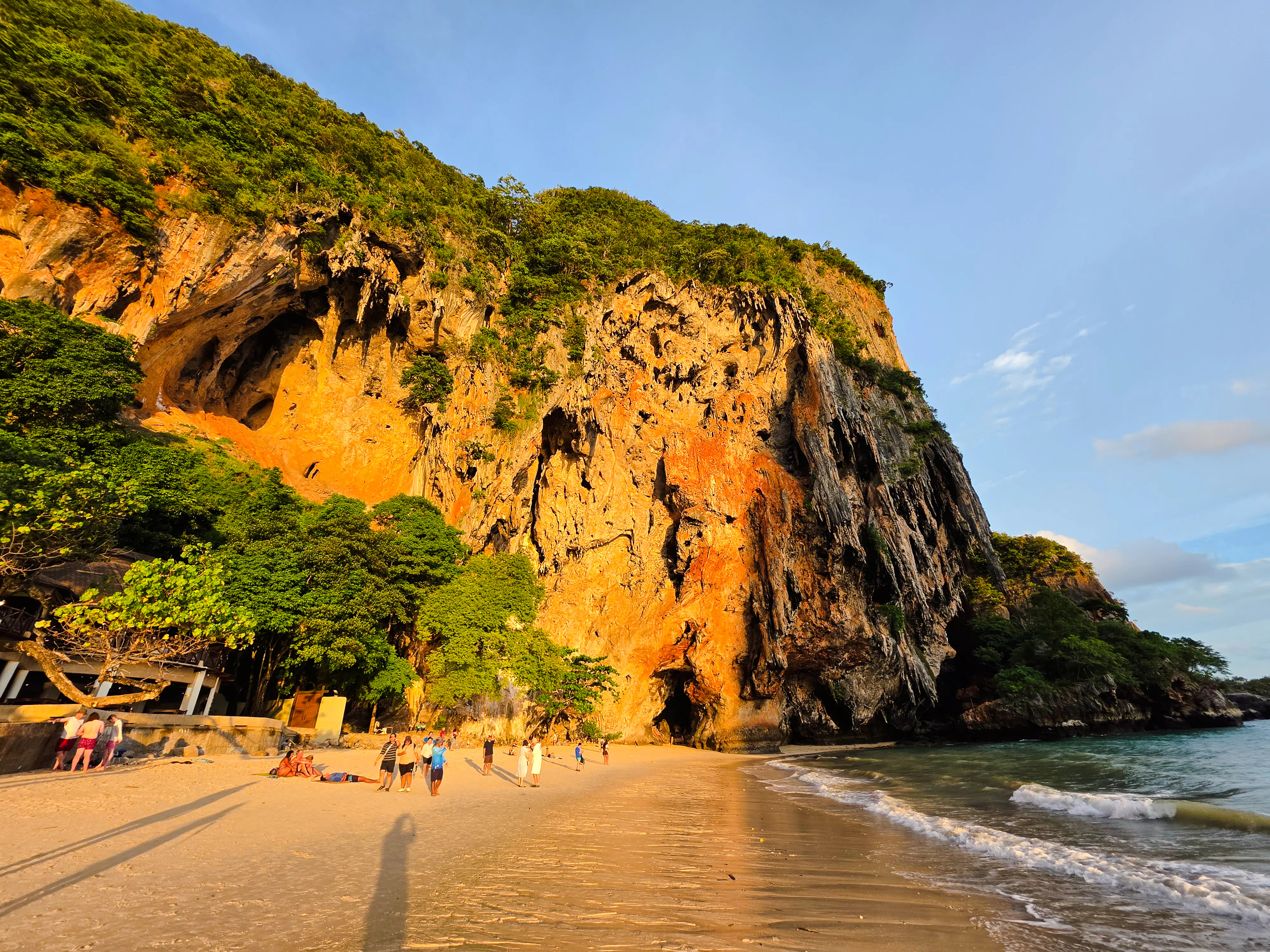 Railay Beach at sunset with limestone cliffs and tourists, Krabi, Thailand.