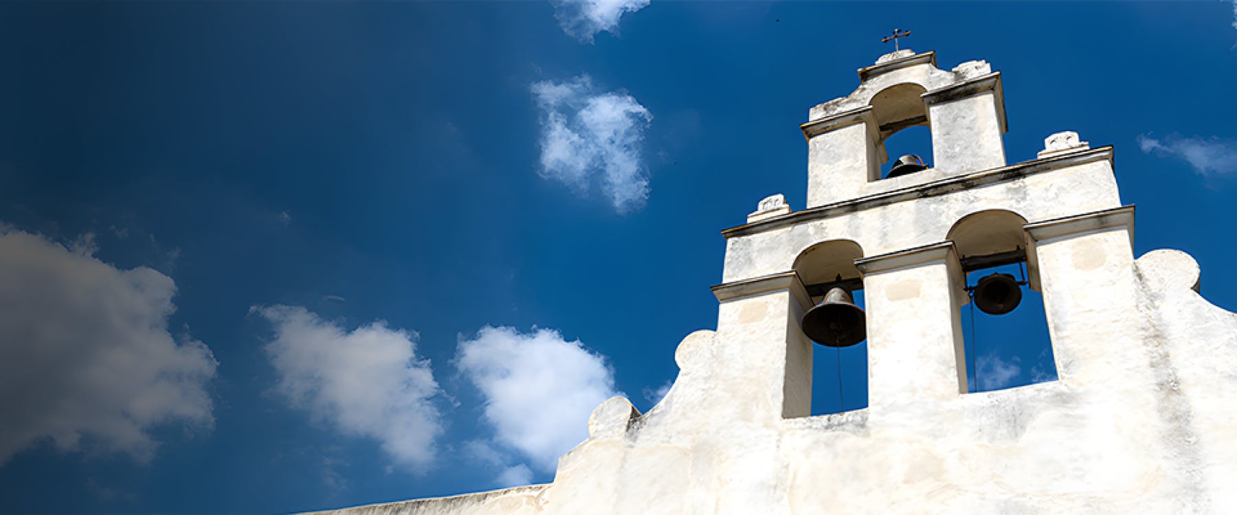 Mission San José bell tower against blue sky, San Antonio, United States.