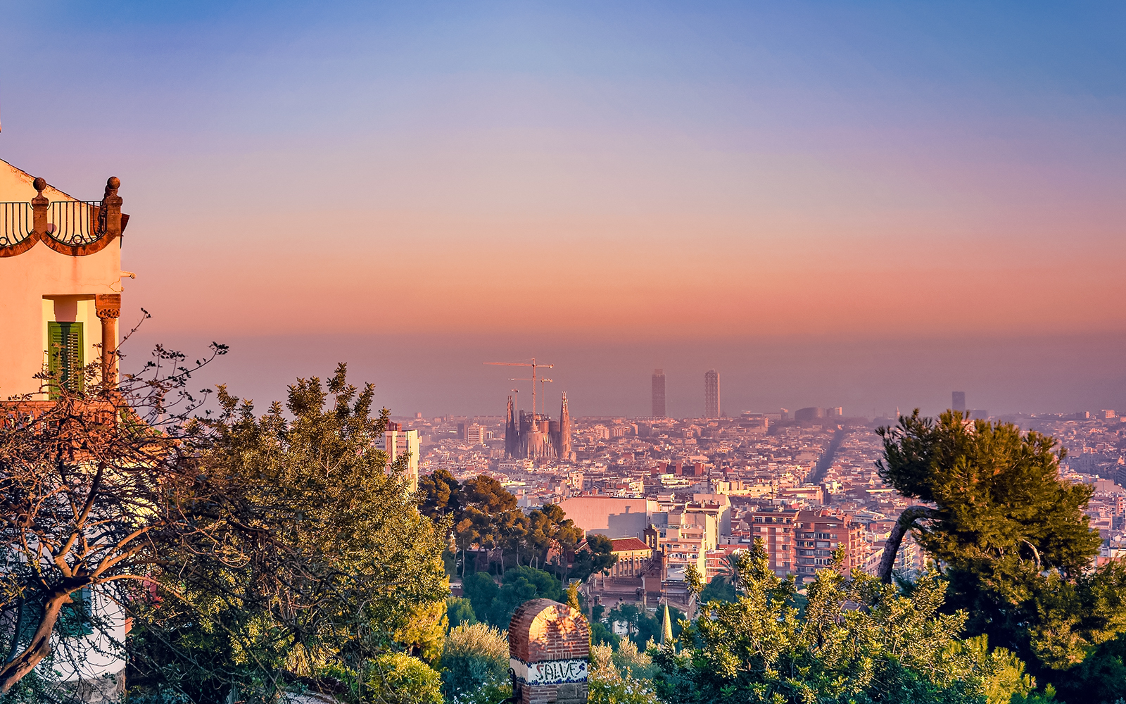 Park Guell sunset view overlooking Barcelona cityscape, highlighting Gaudi's architectural designs.