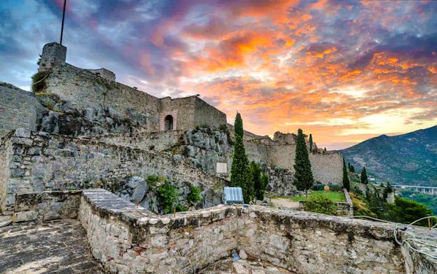 Klis Fortress at sunset with vibrant sky, Croatia.