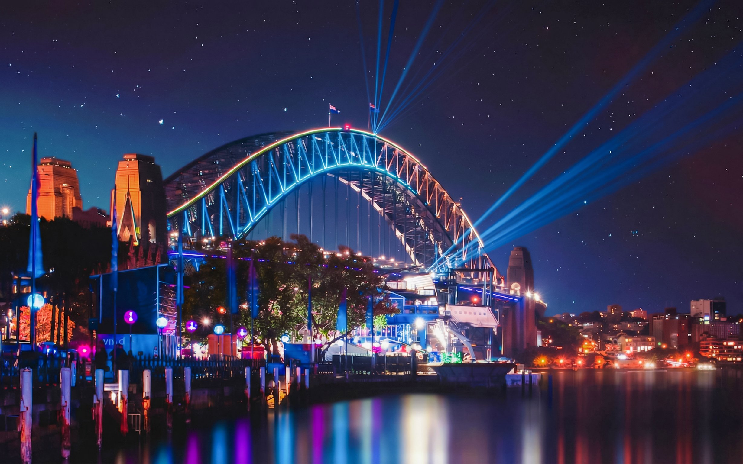 Sydney Harbour Bridge illuminated during Vivid Sydney festival, viewed from a dinner cruise.