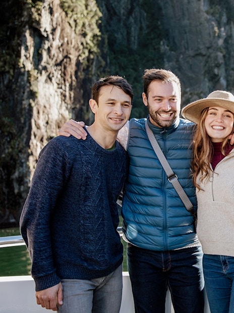 Group enjoying a 2-hour cruise on Milford Sound with scenic cliffs in the background.