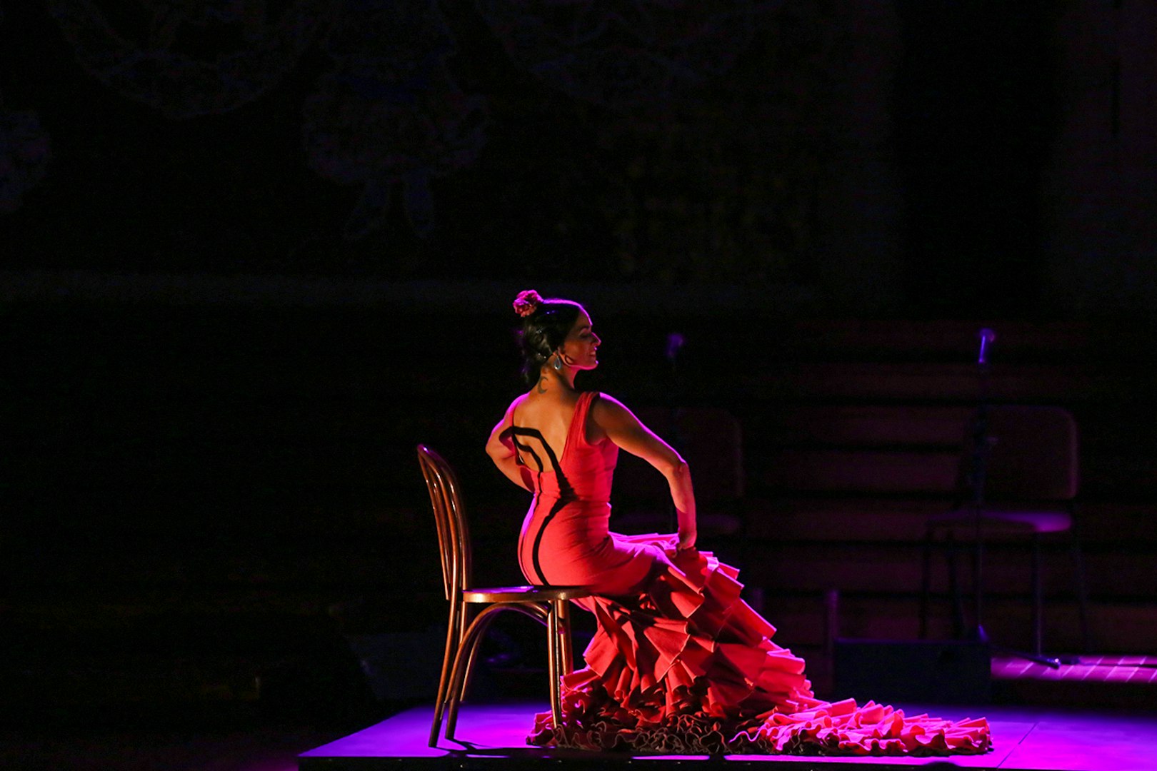 Flamenco dancer in red dress performing at Poliorama Theater's Gran Gala Flamenco Show.