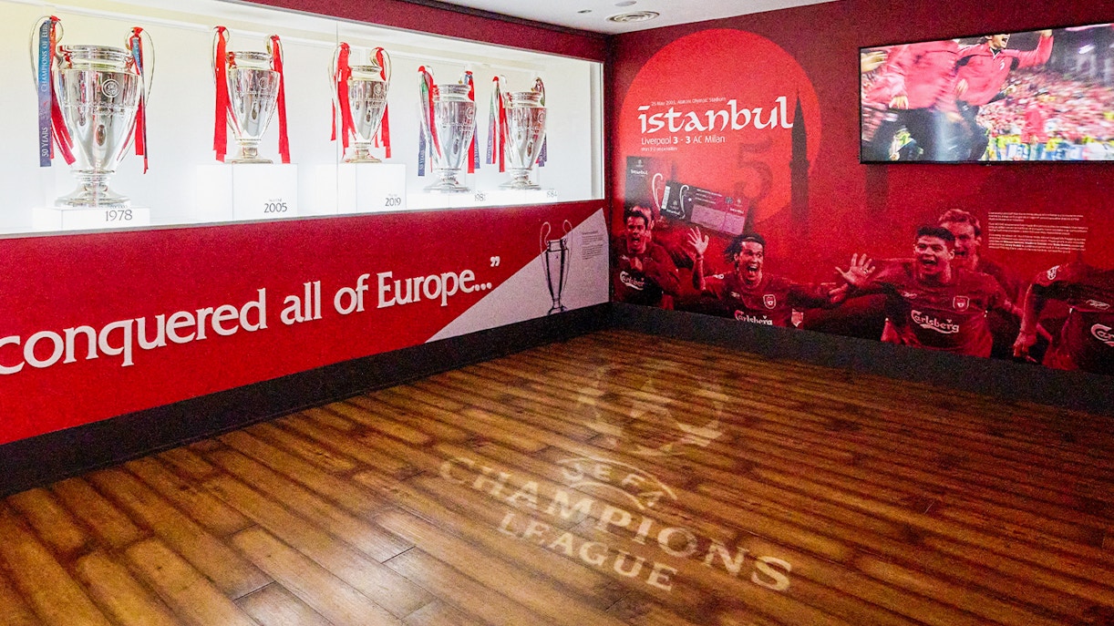Liverpool FC trophies and Istanbul 2005 mural at Anfield Stadium Museum.