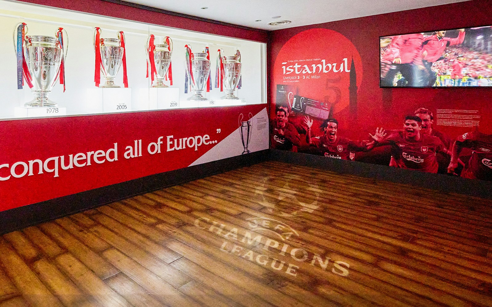 Liverpool FC trophies and Istanbul 2005 mural at Anfield Stadium Museum.