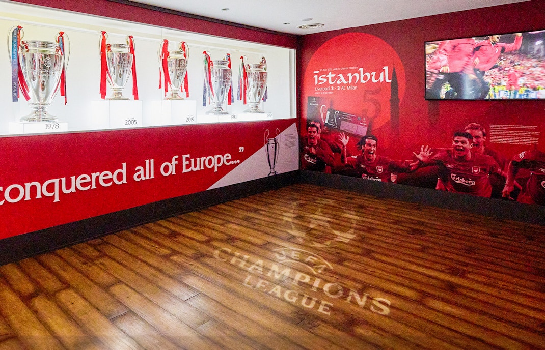 Liverpool FC trophies and Istanbul 2005 mural at Anfield Stadium Museum.