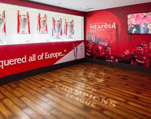 Liverpool FC trophies and Istanbul 2005 mural at Anfield Stadium Museum.