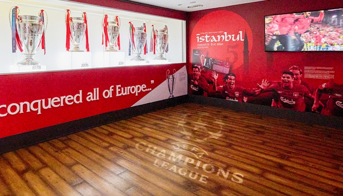 Liverpool FC trophies and Istanbul 2005 mural at Anfield Stadium Museum.