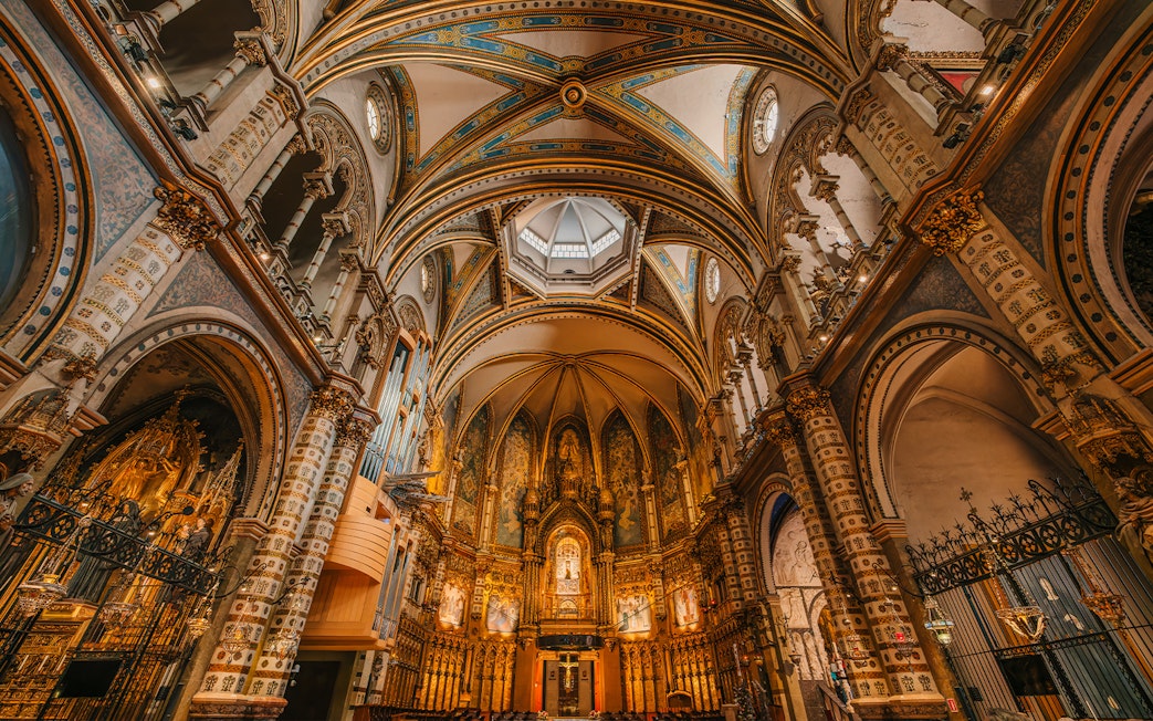 Interior view of Montserrat Monastery's ornate arches and detailed ceiling.