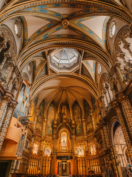 Interior view of Montserrat Monastery's ornate arches and detailed ceiling.