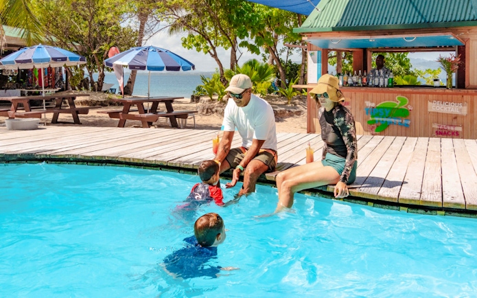 Kids swimming in a pool as parents supervise at South Sea Island, Fiji.