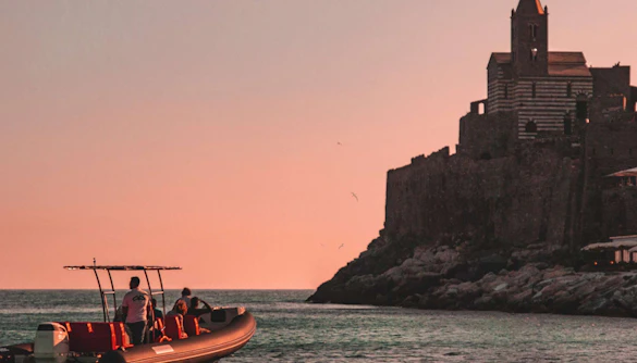 Boat approaching Portovenere church at sunset, La Spezia boat trip.