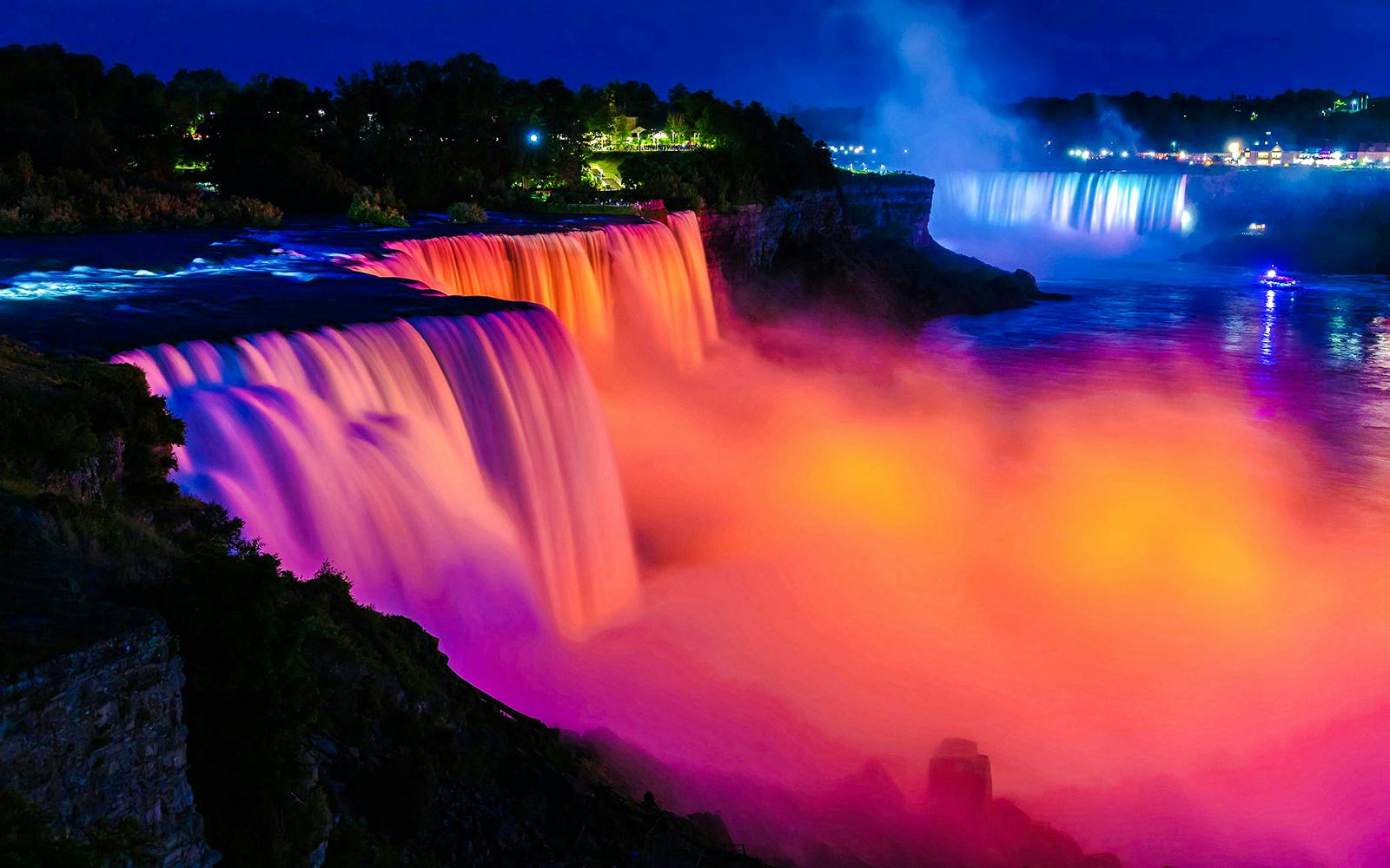 Niagara Falls illuminated at night with vibrant colors, USA.