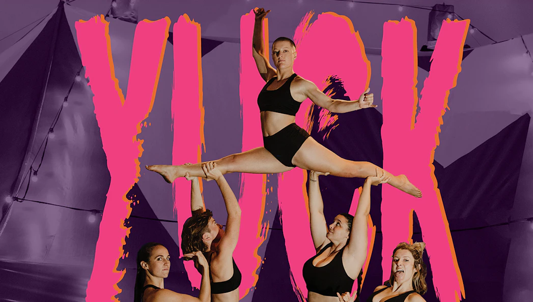 Acrobats performing a lift at YUCK Circus with a vibrant backdrop.