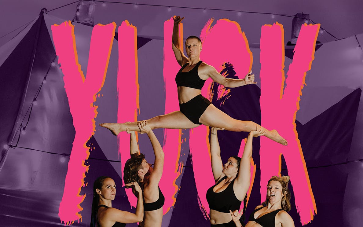 Acrobats performing a lift at YUCK Circus with a vibrant backdrop.