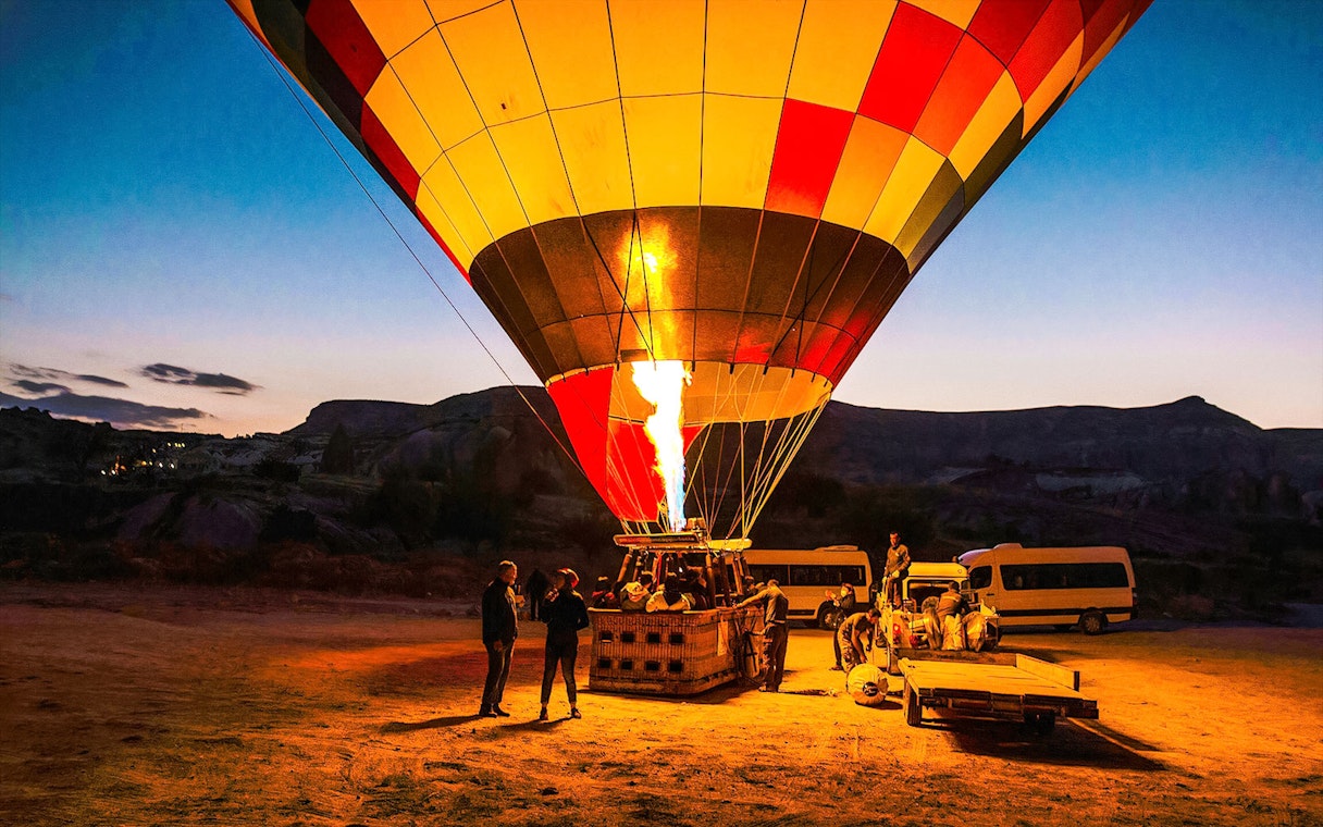 Hot air balloon being prepared for flight at sunrise in Cappadocia, Turkey.