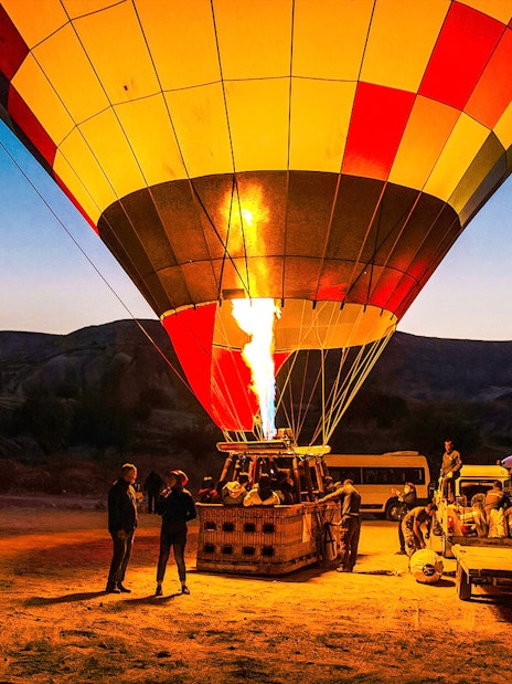 Hot air balloon being prepared for flight at sunrise in Cappadocia, Turkey.