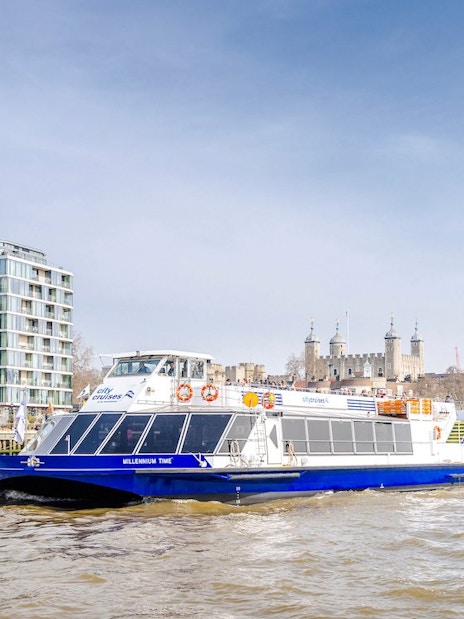 Cruise boat on the Thames River with the Tower of London in the background.