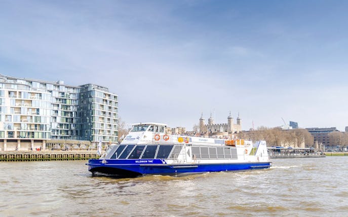 Cruise boat on the Thames River with the Tower of London in the background.