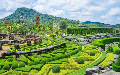 Nong Nooch Tropical Garden's intricate hedges and stone structures in Pattaya, Thailand.