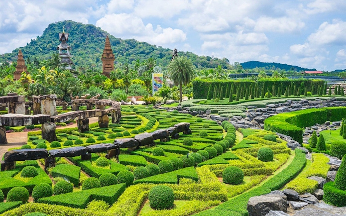 Nong Nooch Tropical Garden's intricate hedges and stone structures in Pattaya, Thailand.