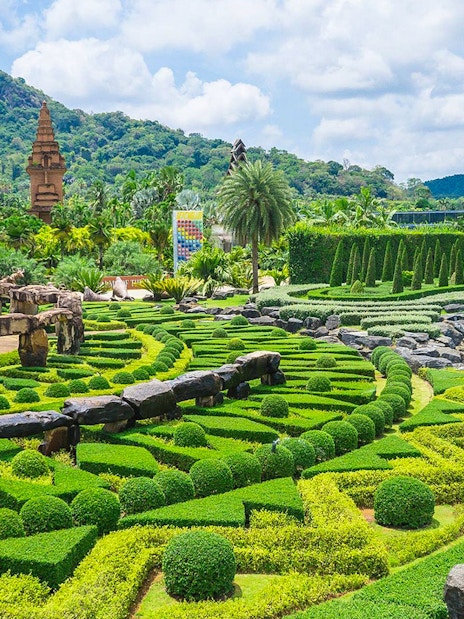 Nong Nooch Tropical Garden's intricate hedges and stone structures in Pattaya, Thailand.