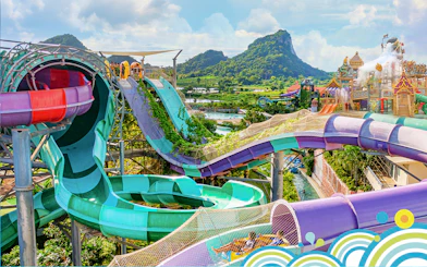 Water slides and attractions at Ramayana Water Park with lush greenery and mountain views.