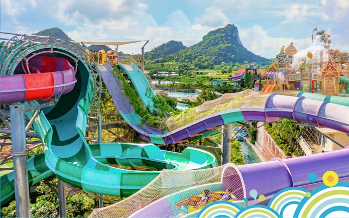 Water slides and attractions at Ramayana Water Park with lush greenery and mountain views.