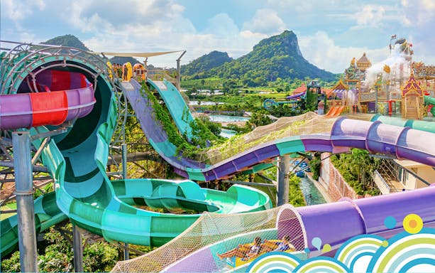 Water slides and attractions at Ramayana Water Park with lush greenery and mountain views.