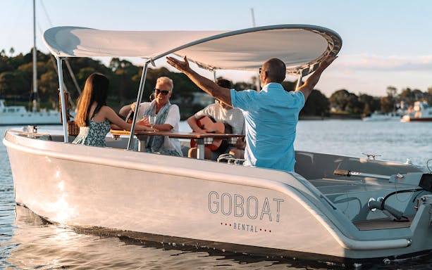 Self-drive electric picnic boat with people enjoying a tour in Sydney.