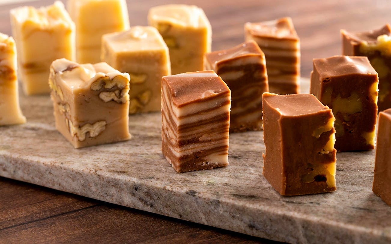 Assorted fudge pieces on a wooden table.