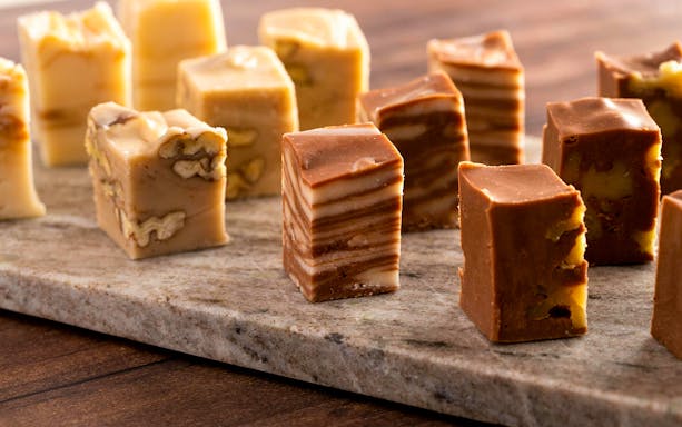 Assorted fudge pieces on a wooden table.