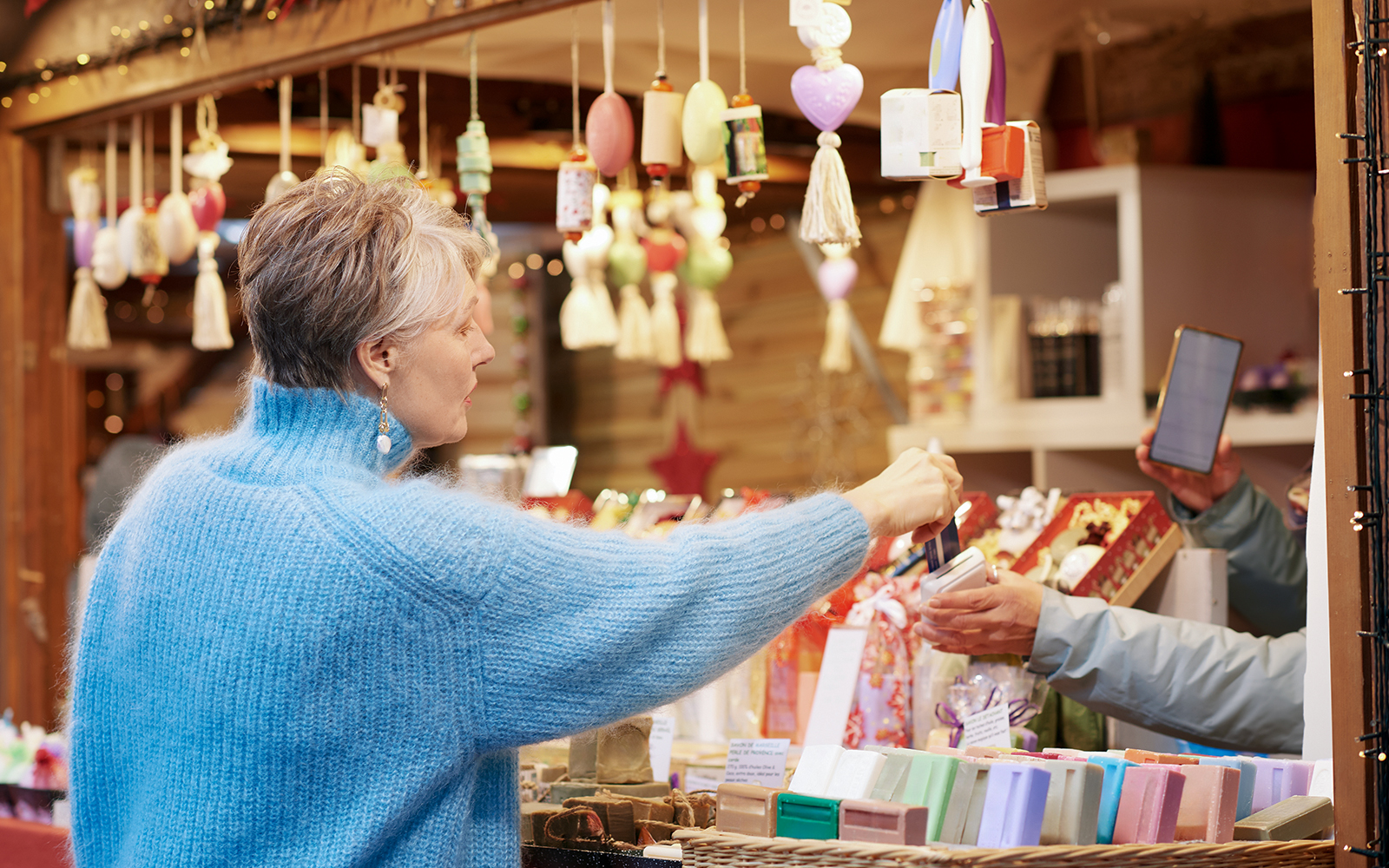 Old woman purchasing items at a Paris gift shop.