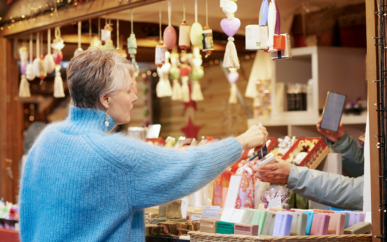 Old woman purchasing items at a Paris gift shop.