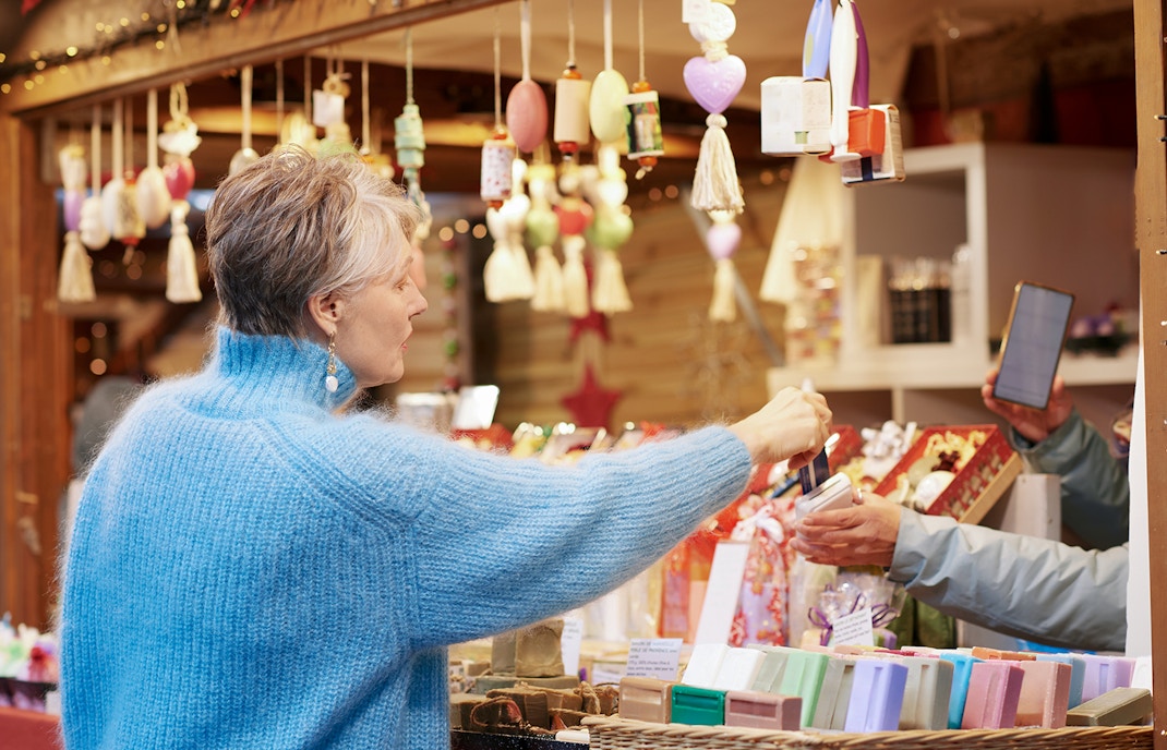 Old woman purchasing items at a Paris gift shop.