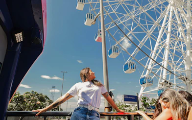 Hop-on hop-off bus tour in Rio de Janeiro with view of Ferris wheel.
