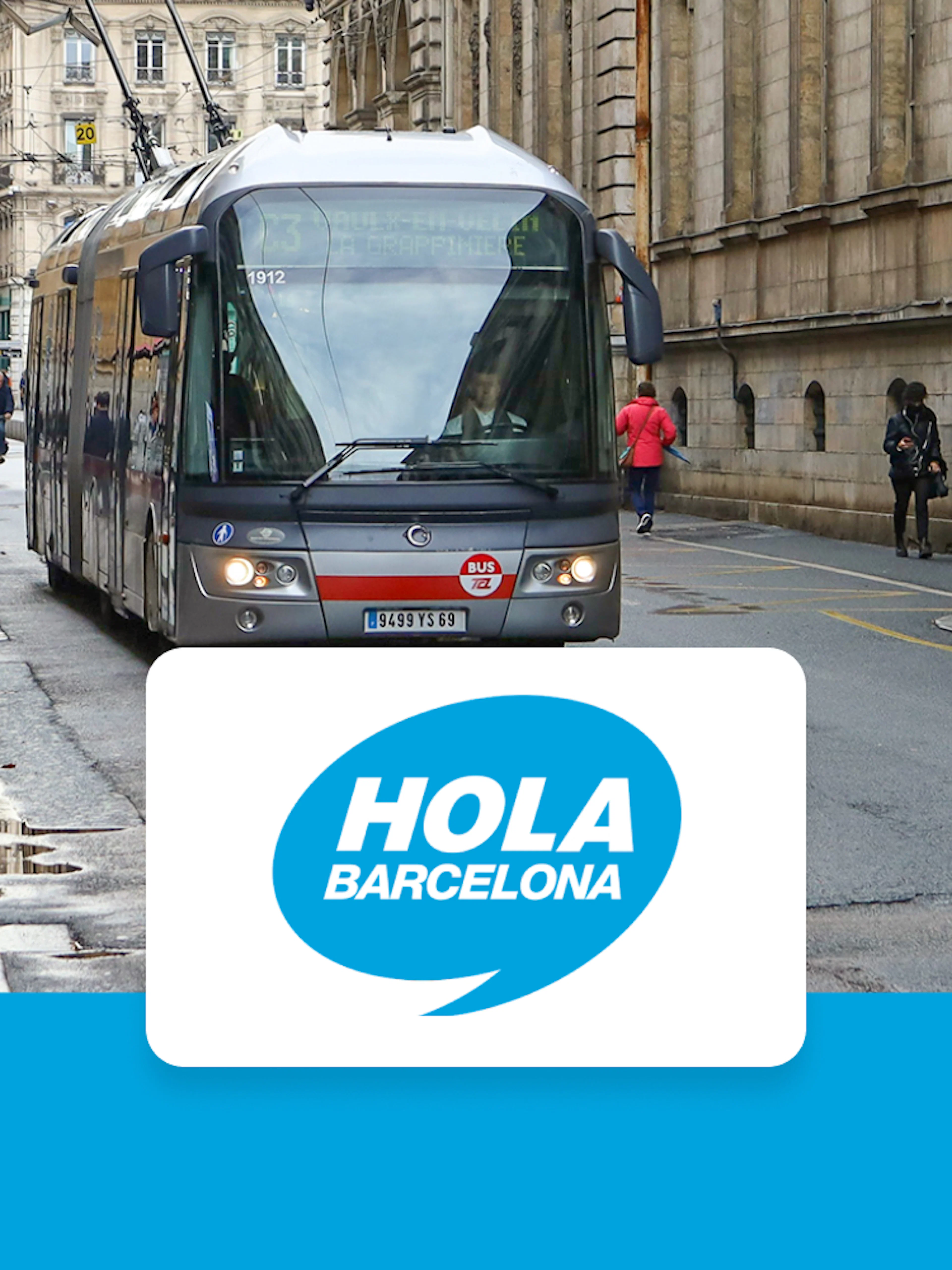 Tram on a busy street in Barcelona with Hola Barcelona logo.