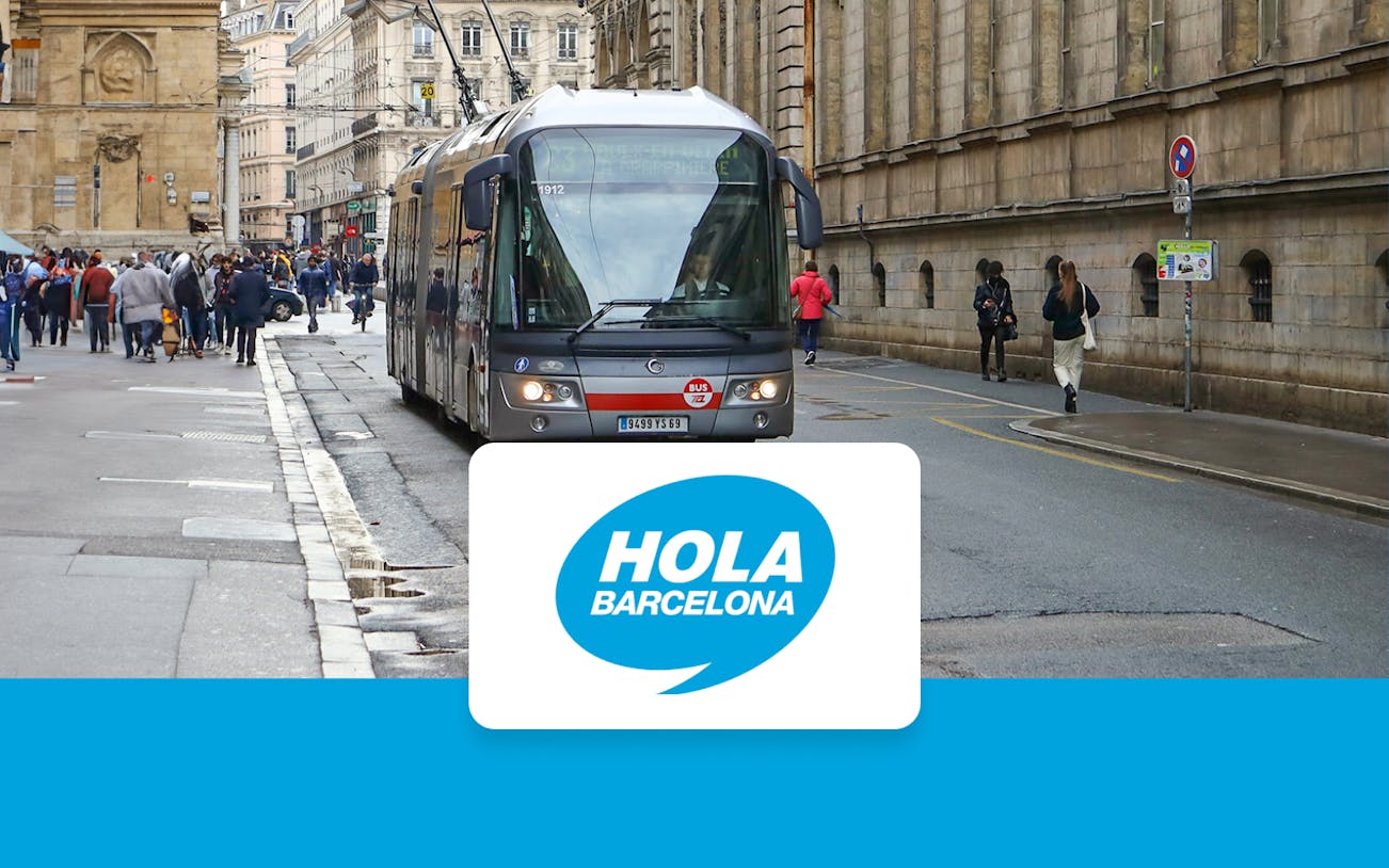 Tram on a busy street in Barcelona with Hola Barcelona logo.