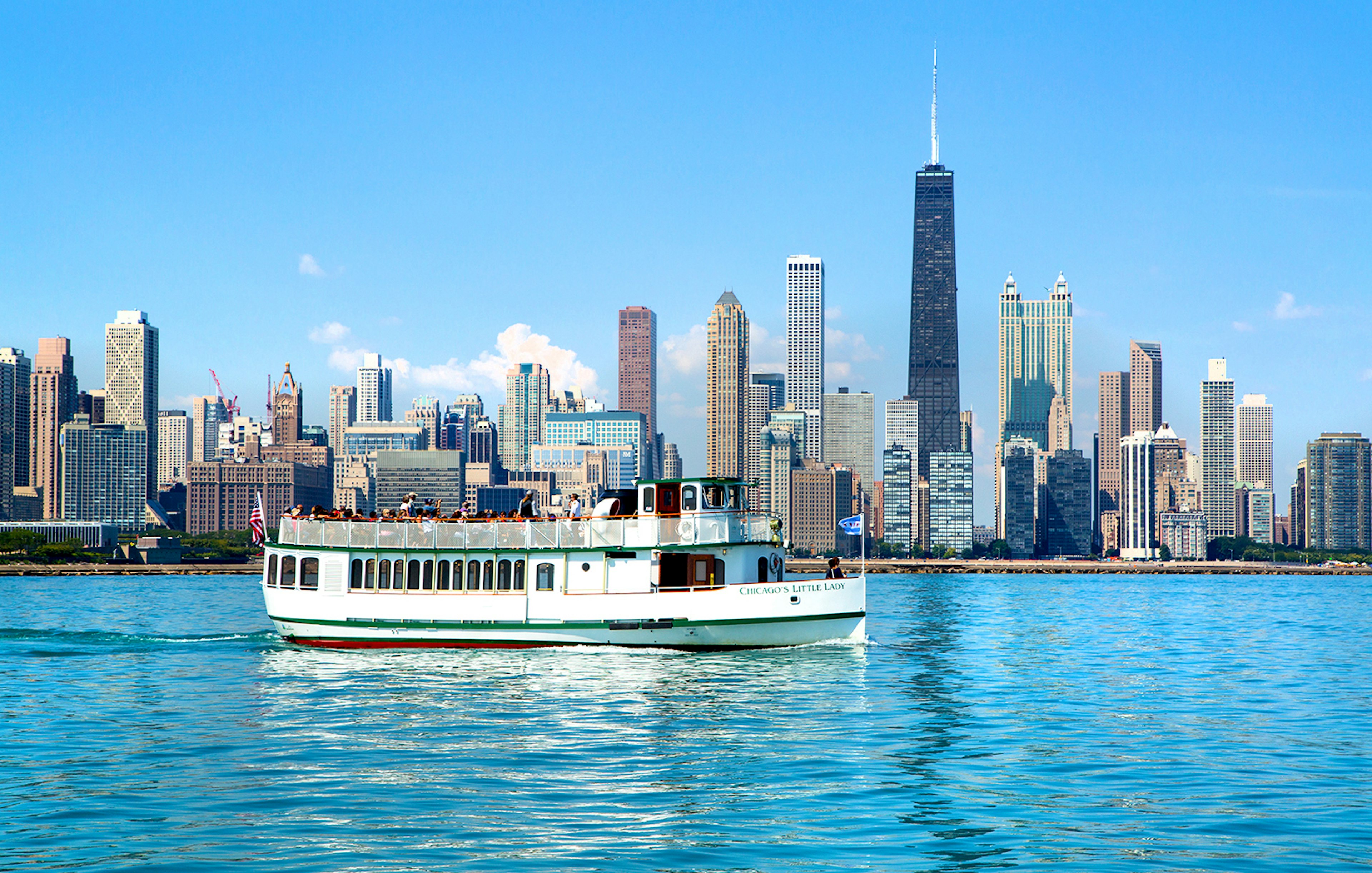 Chicago River cruise boat with city skyline in the background.