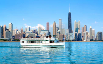 Chicago River cruise boat with city skyline in the background.