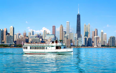 Chicago River cruise boat with city skyline in the background.